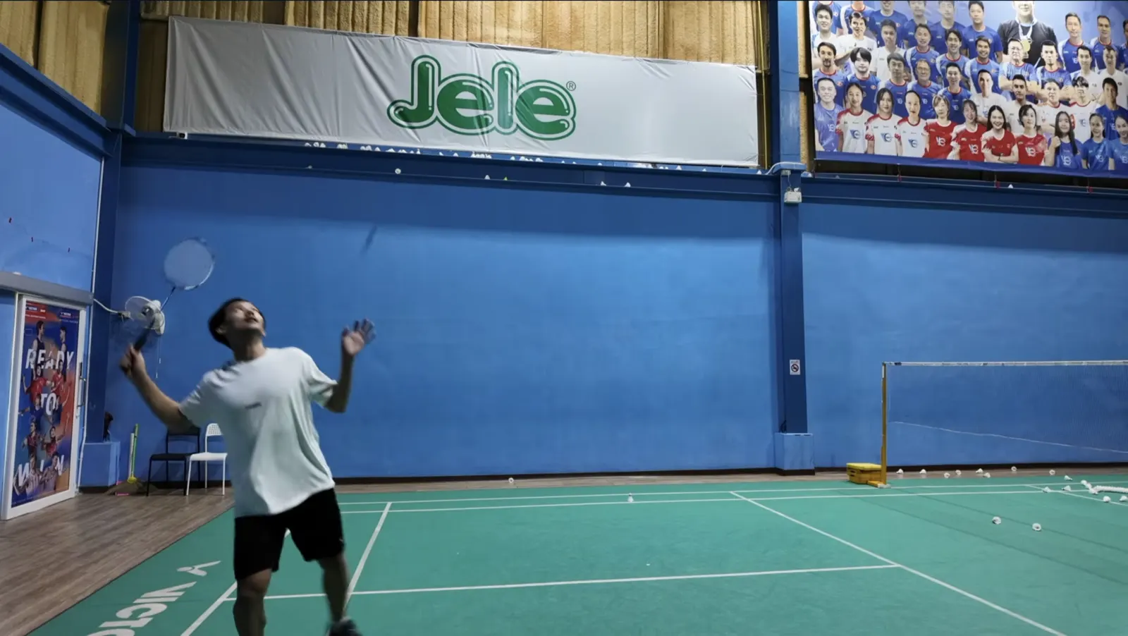 Joueur frappant un dégagement long en fond de court au badminton