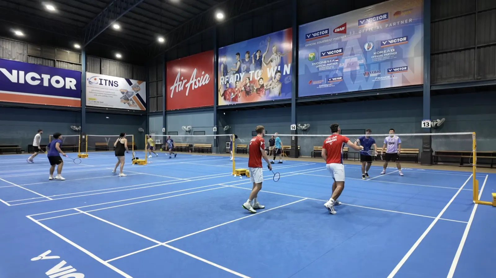 Joueurs en double prêts à recevoir un service tactique au badminton