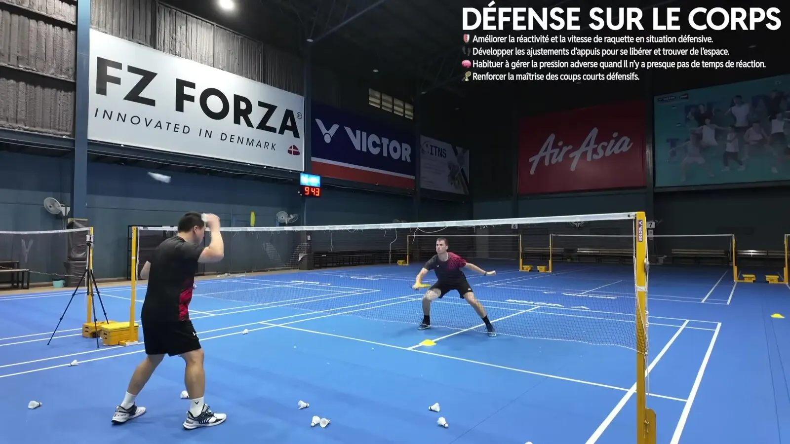 Joueur en défense sur le corps pendant un exercice en salle, situation où se filmer montre si la raquette tourne en main