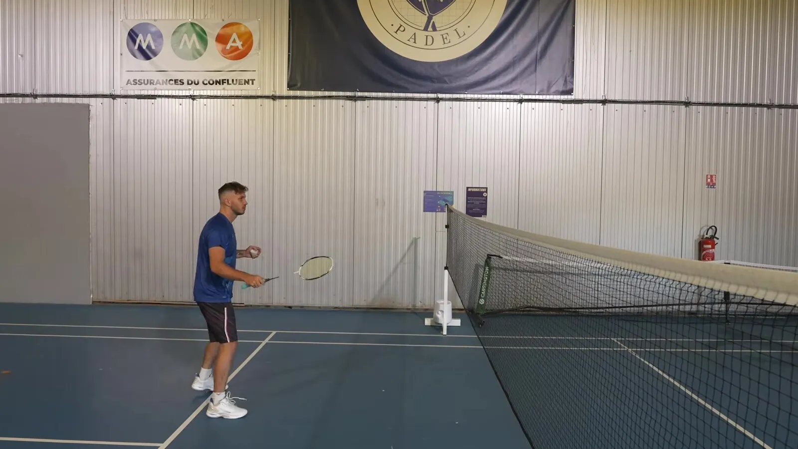 Joueur près du filet, raquette devant lui, qui prépare un geste court sans armer au badminton