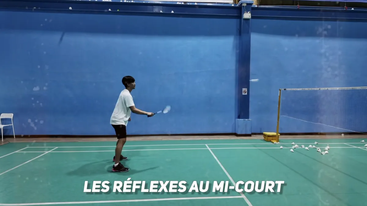 Gestes techniques du badminton au mi-court : joueur en position de drive avec raquette tendue à plat pour un échange rapide