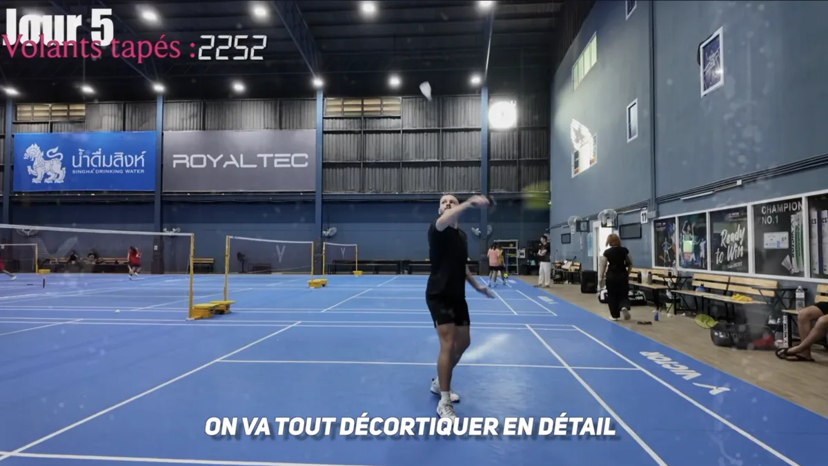 Gestes techniques du revers en fond de court au badminton : joueur en position de dégagement revers avec rotation du corps