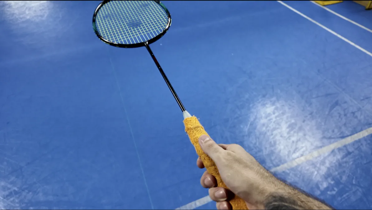 Prise de raquette revers au badminton : pouce sur la partie large du manche, main positionnée en haut du grip pour un levier court