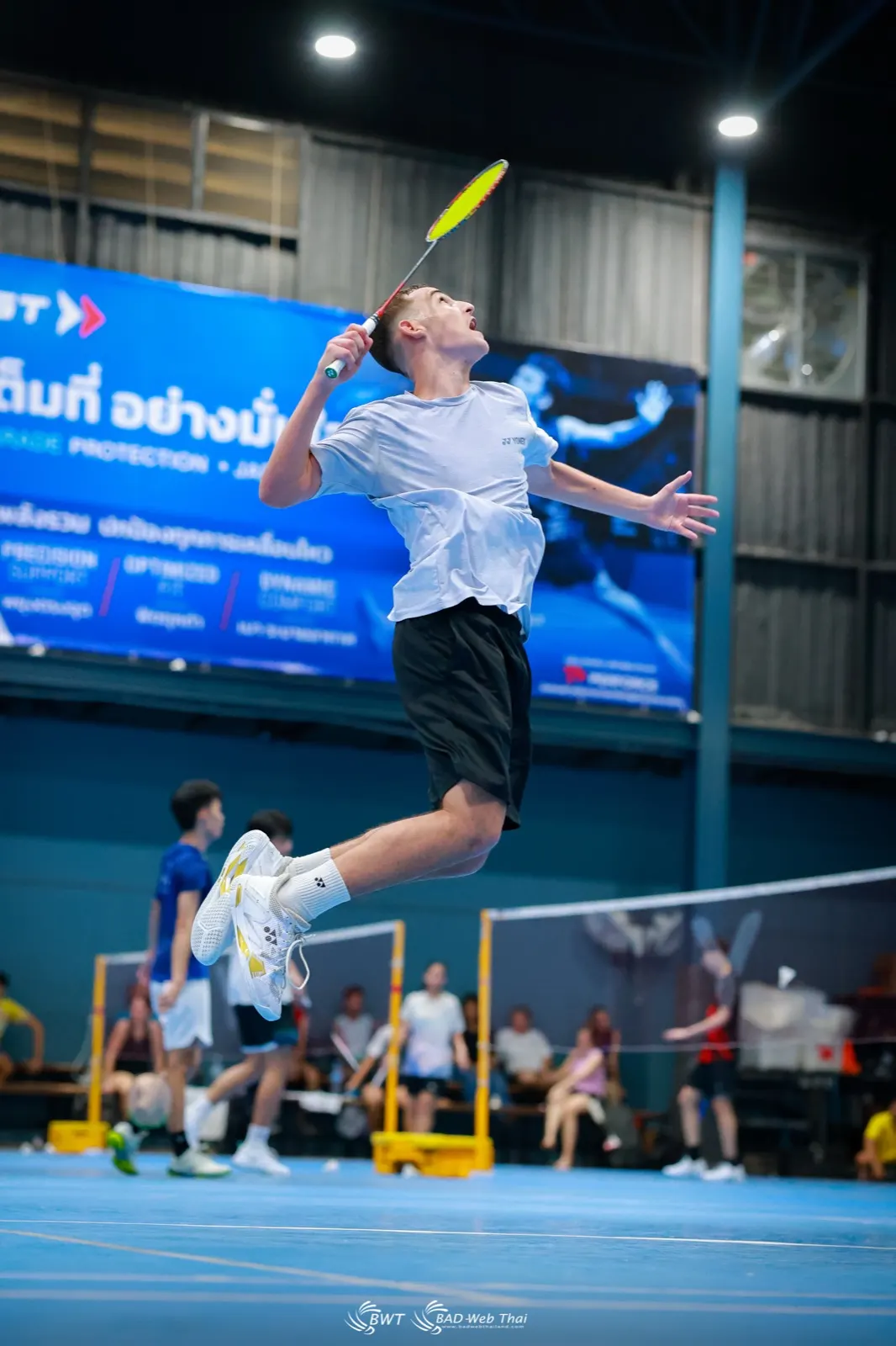 Smash sauté pendant le stage de badminton à Bangkok, corps gainé en l'air